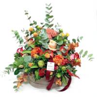 composizione in scatola rotonda con fiori autunnali ed eucalipto