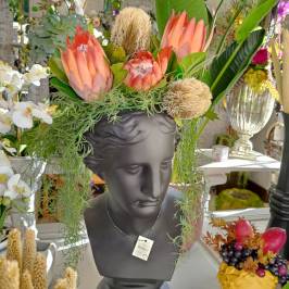 Vaso decorativo a forma di testa nera satinata con fiori artificiali
