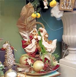 composizione natalizia su piatto con Sacra Famiglia e foglia orata decorativa